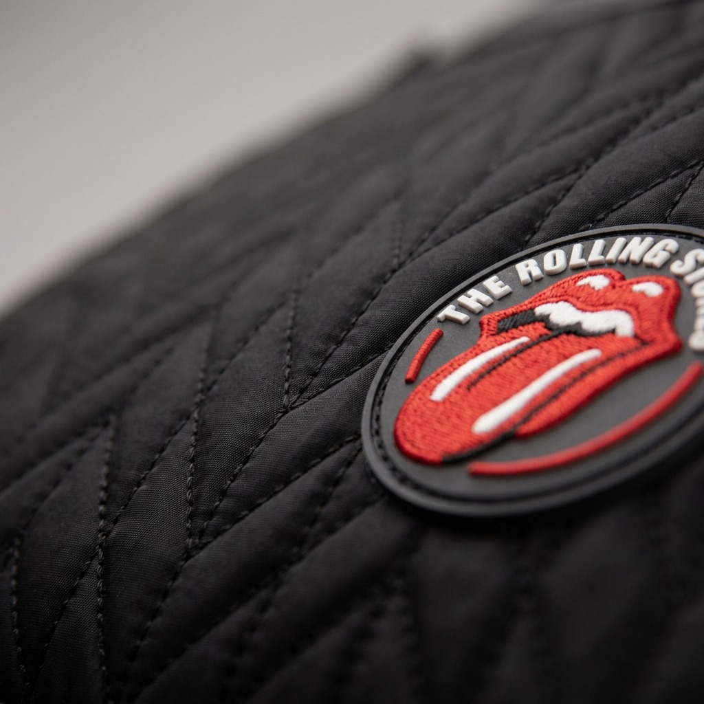 A premium, high-resolution hero shot of the **Bugatti Rolling Stones Iconic Backpack (BKP6066RS)**, showing its full-front quilted nylon construction and signature red tongue logo.
