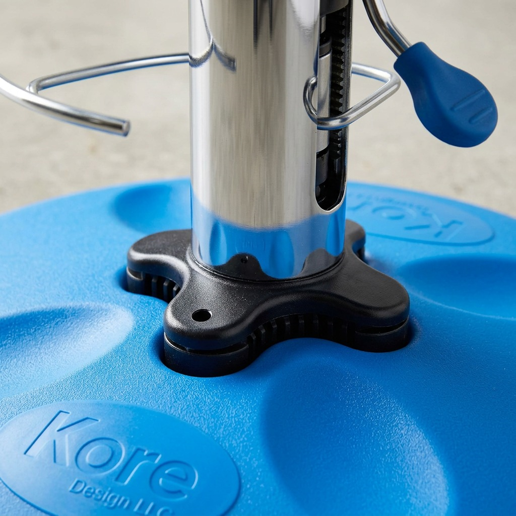 Close-up of fdmt Kore Wobble Stool's adjustable chrome piston, base connector, and blue textured seat.