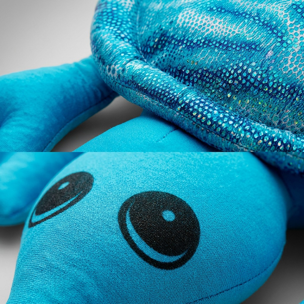 Macro shot shows the tactile sequin turtle shell pattern and a sharp close-up of its printed eye detail.