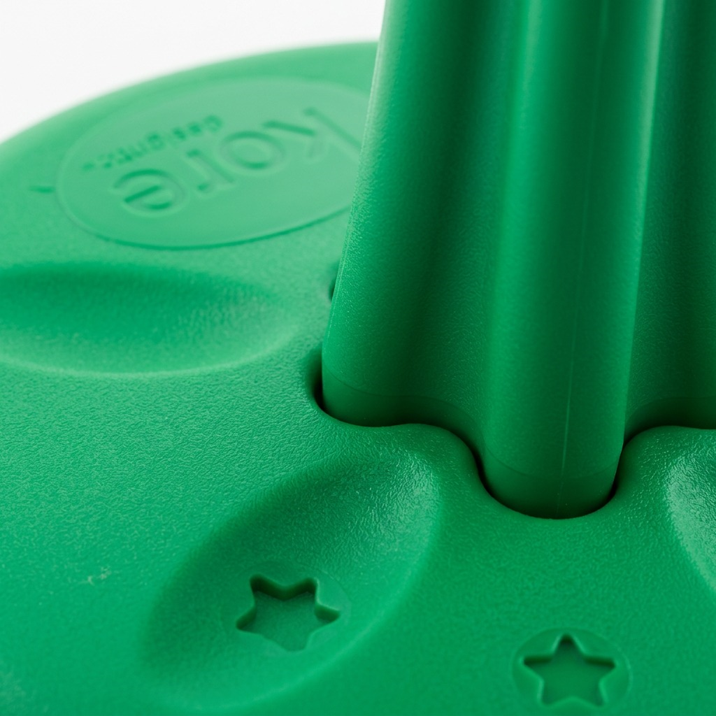 Macro close-up of green fdmt Kore Wobble Stool showing textured plastic base with star patterns.