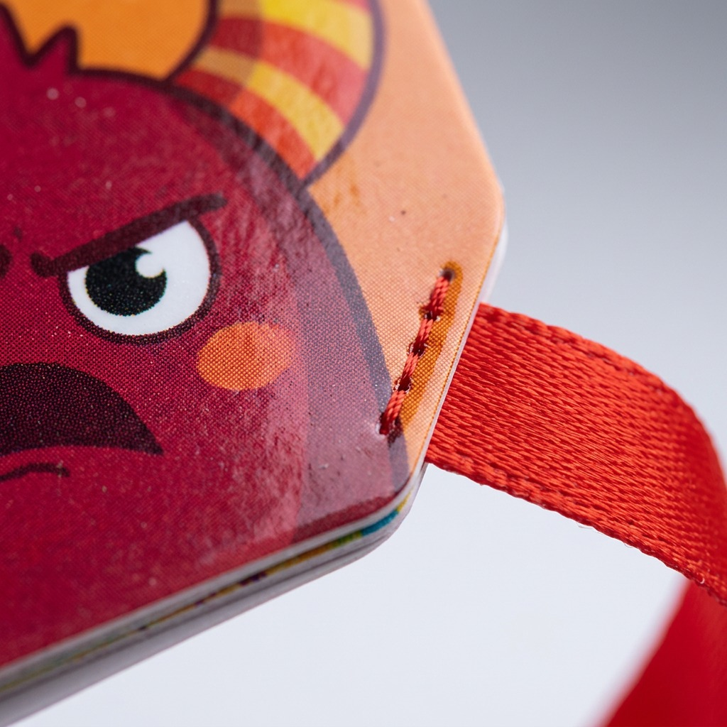 Macro view of durable card texture and ribbon leash attachment point on the activity tags.